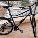 Vélo d’occasion en très bon état, détail du cadre bleu et noir et du guidon.